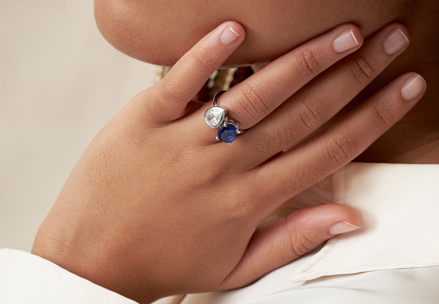 The Gem Bezel Toi et Moi with a pear-cut diamond and oval-cut blue sapphire by Holden on hand