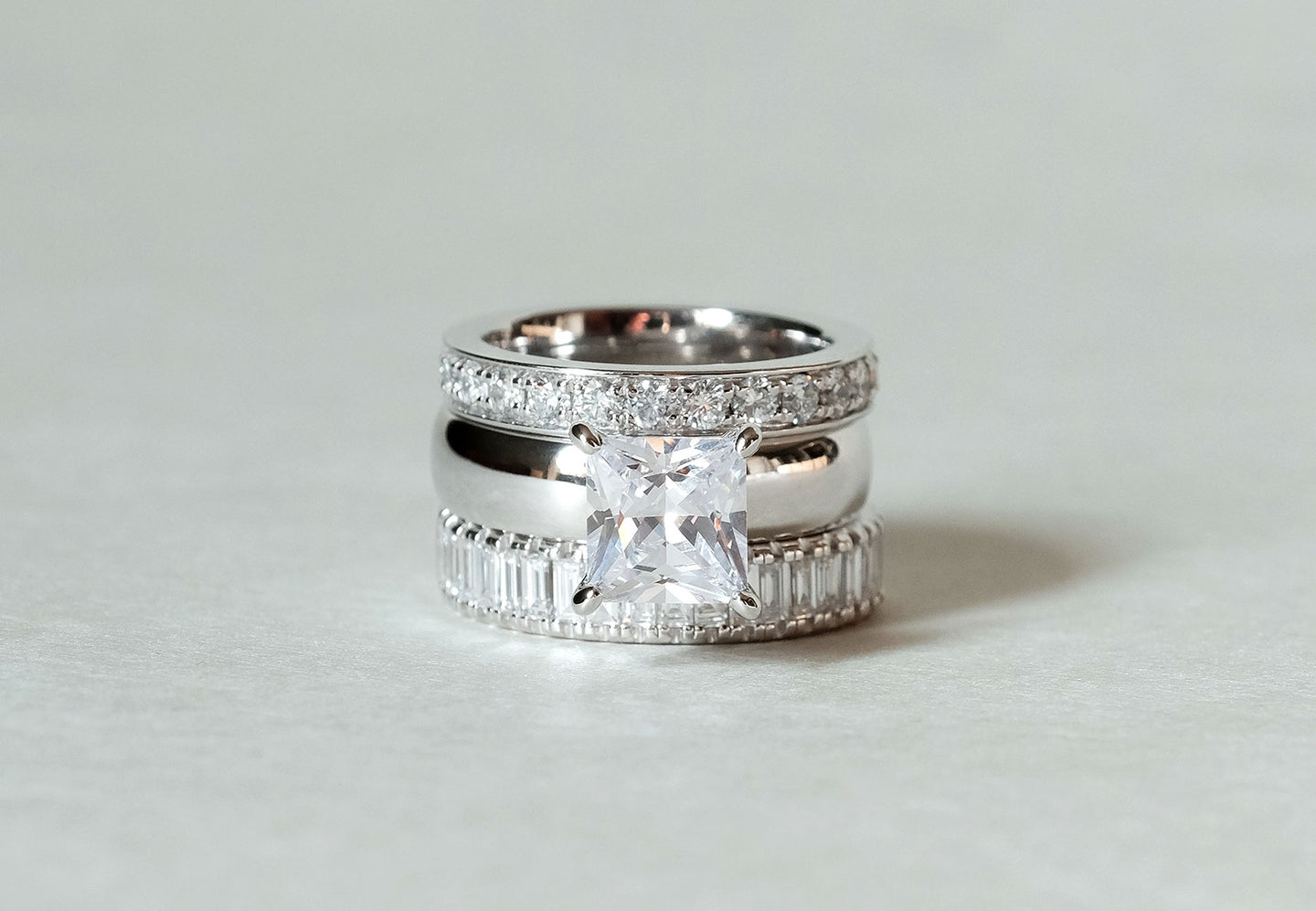 Top to bottom: The Channel Eternity, The Domed Solitaire with a Princess Diamond, and The Column Baguette rings stacked