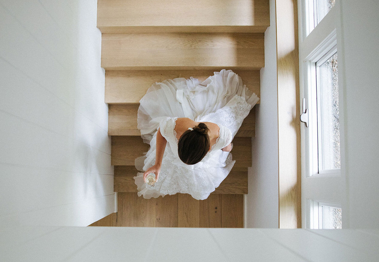 Bride walking down stairs from a bird's eye view; photo courtesy of Sarah Kusz Weddings.