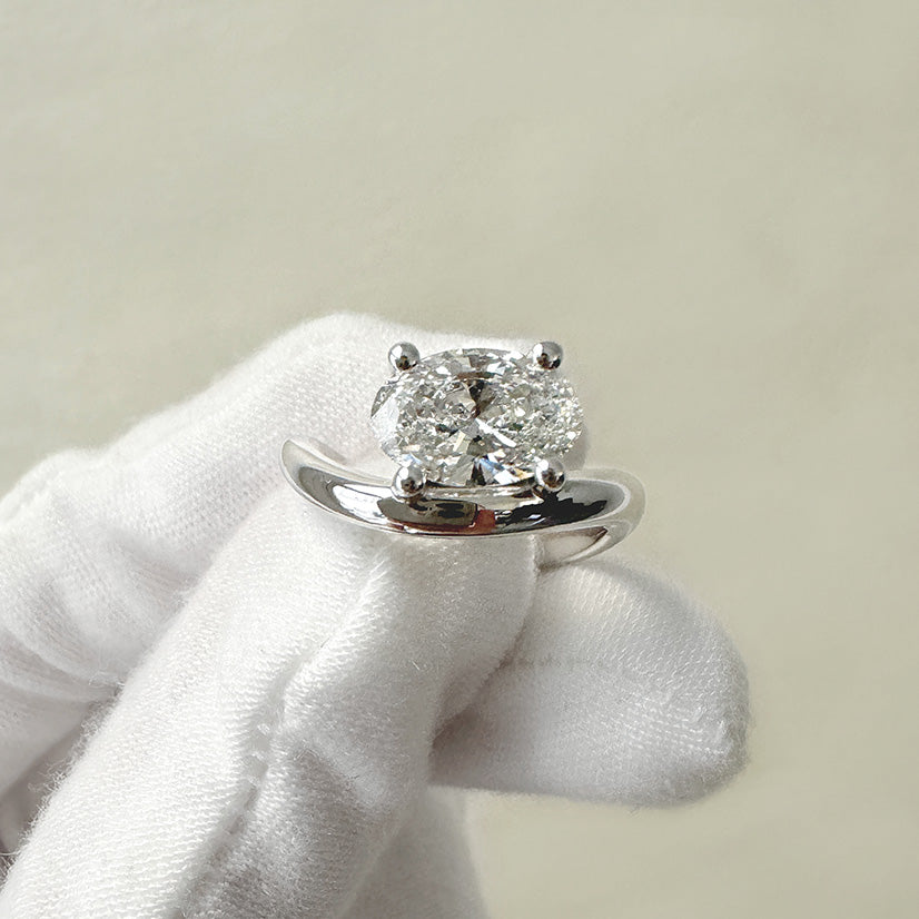 Fully custom wavy white gold engagement ring with an oval cut diamond by Holden